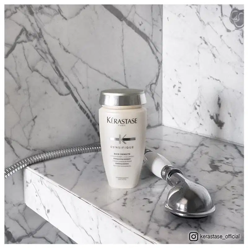 Dois produtos da marca Kérastase: um frasco de shampoo Bain Densité e um tubo de condicionador Fondant Densité, ambos em embalagens brancas e prateadas com o logotipo da marca.