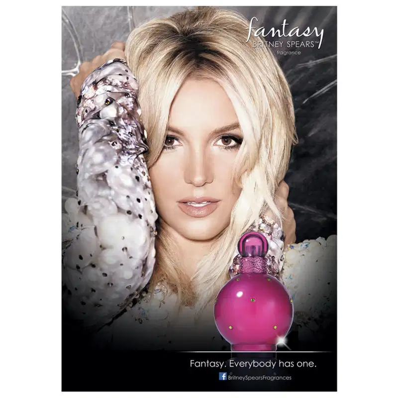 Embalagem promocional mostra Britney Spears com cabelos loiros curtos, usando um casaco estampado cinza e branco. Texto "Fantasy. Everybody has one." (Fantasia. Todo mundo tem uma.) e o logotipo do Facebook Britney Spears Fragrances.