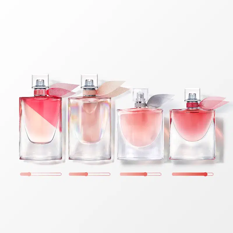 Quatro frascos de perfume Lancôme em diferentes tamanhos, com tonalidades rosadas e detalhes prateados na embalagem. Os produtos apresentam design elegante e sofisticado, com rótulos e tampas que sugerem fragrâncias delicadas e femininas.