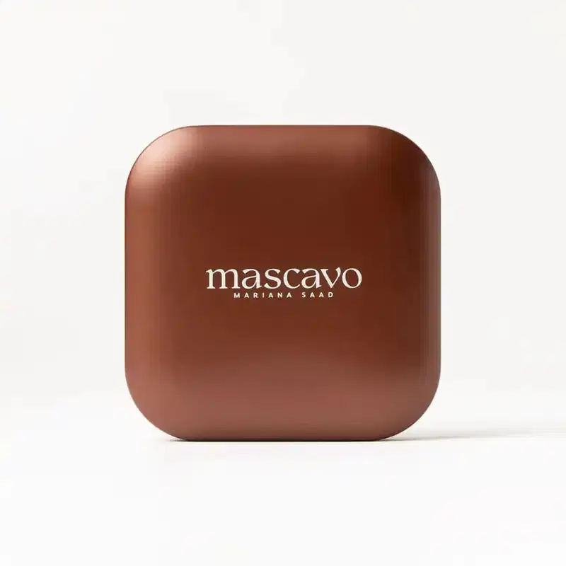 A embalagem tem cor marrom escura, com o nome "mascavo" escrito em letras brancas. Possui um formato quadrado e design minimalista.