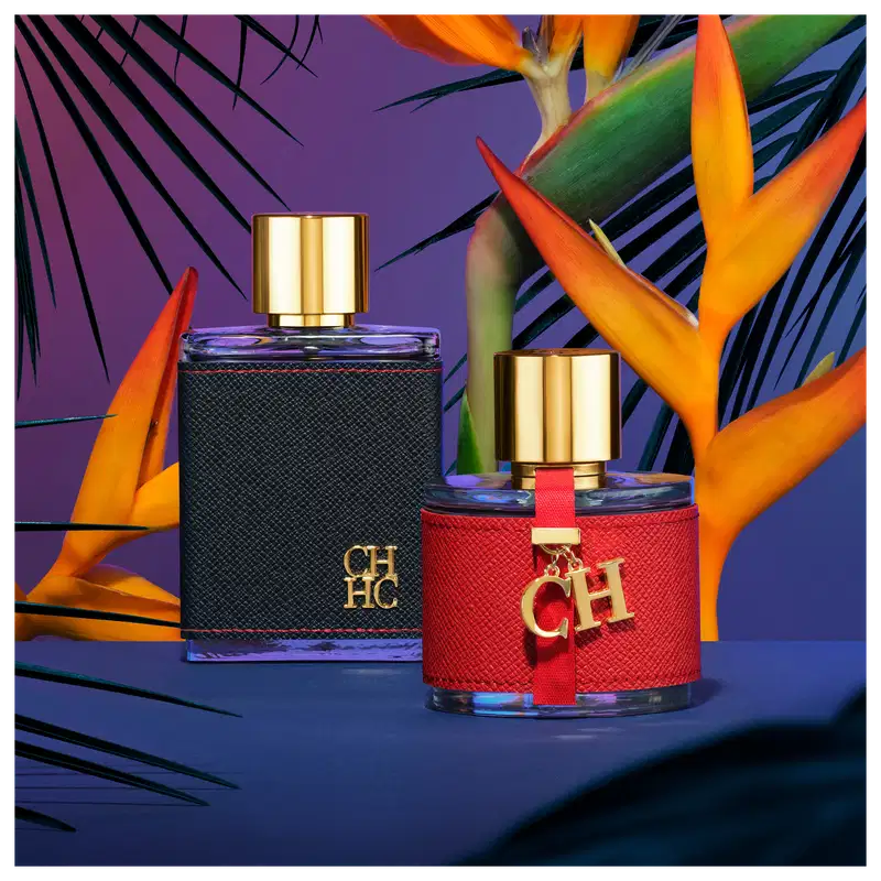 A imagem mostra dois frascos de perfumes, da mesma coleção. Um maior, retangular, com capa preta e tampa dourada, e um menor, arredondado, com capa vermelha e tampa dourada. Ambos apresentam a logo da marca em alto relevo.