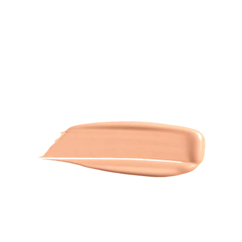 A imagem mostra uma porção de base líquida da marca de maquiagem Wet n Wild, depositada em uma superfície de fundo branco. O produto possui um acabamento brilhante e sedoso, de fácil espalhabilidade.