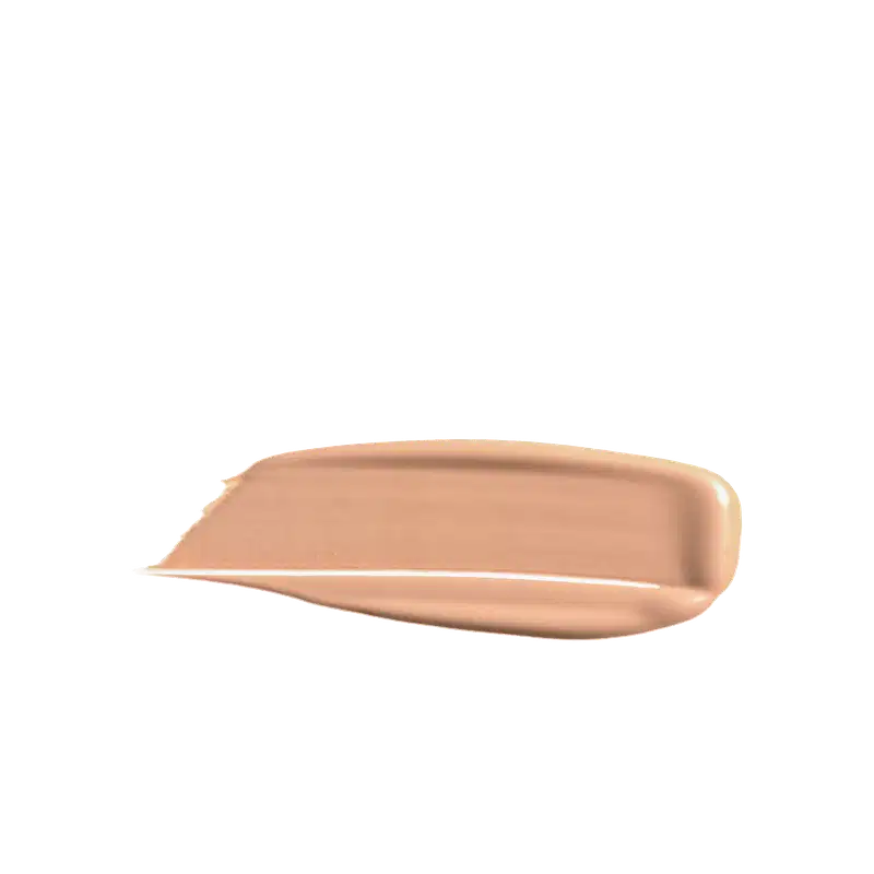 A imagem mostra uma porção de base líquida da marca de maquiagem Wet n Wild, depositada em uma superfície de fundo branco. O produto possui um acabamento brilhante e sedoso, de fácil espalhabilidade.