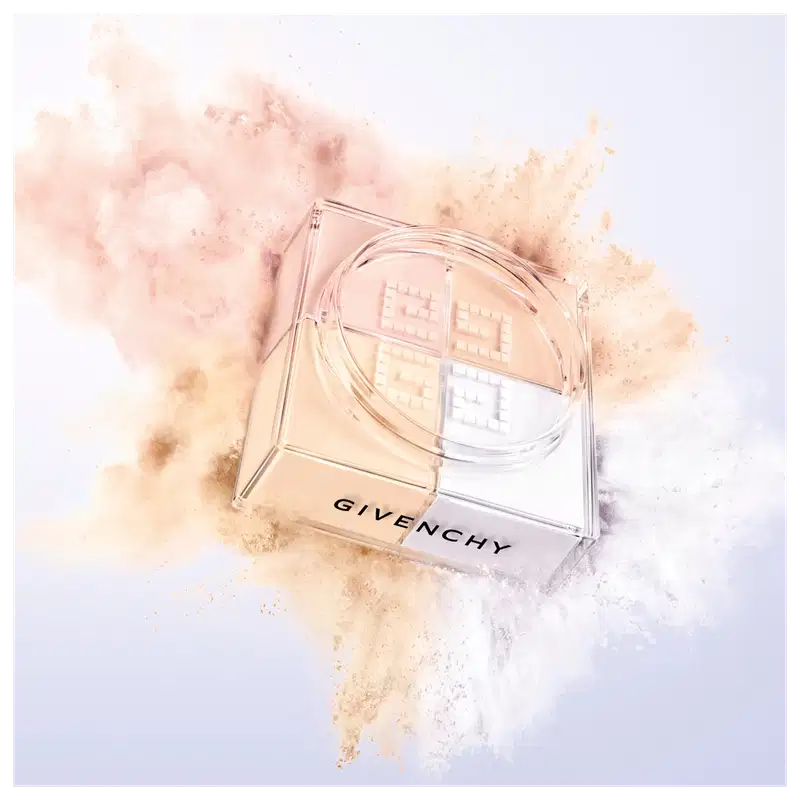 A imagem mostra a embalagem do pó solto e ao redor tem uma explosão das cores do pó, representando o poder e arte de givenchy.