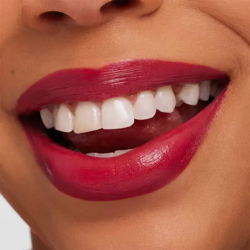 A imagem mostra a boca de uma mulher usando o batom.