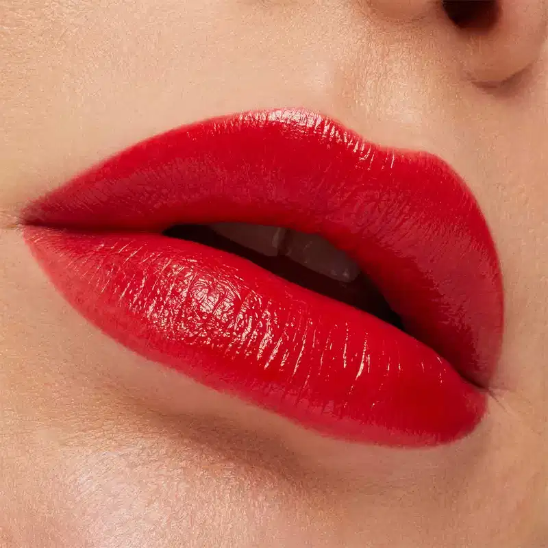 A imagem mostra a boca de uma mulher usando o batom.