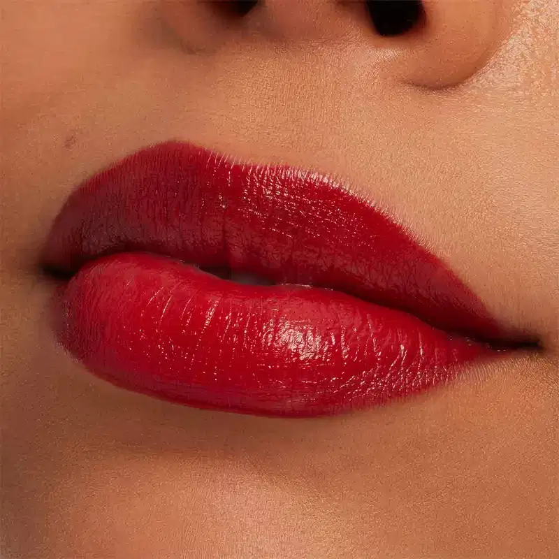 A imagem mostra a boca de uma mulher usando o batom.