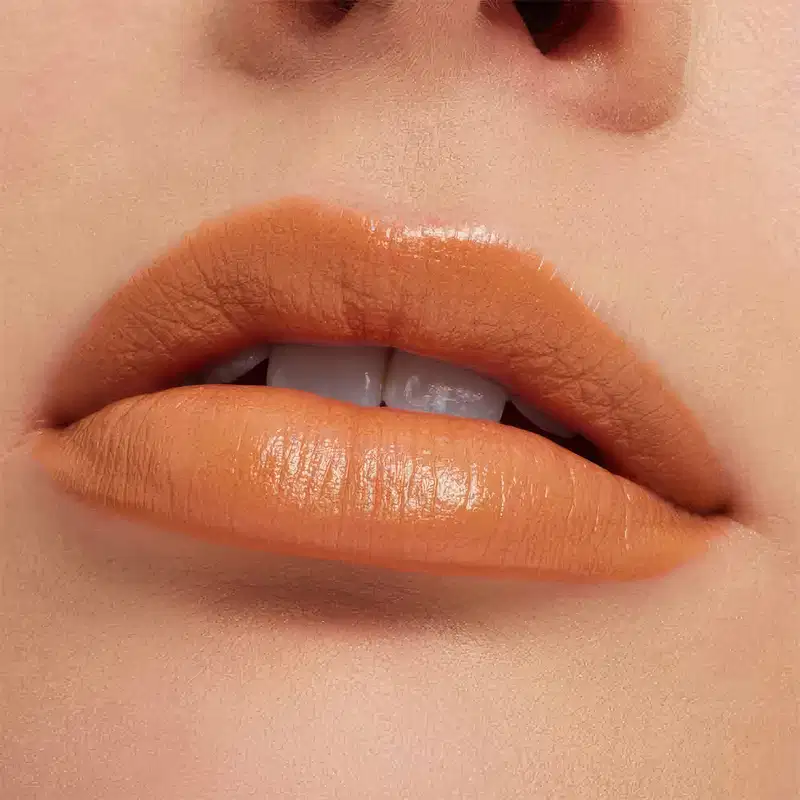 A imagem mostra a boca de uma mulher usando o batom.