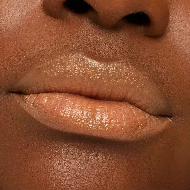 A imagem mostra a boca de uma mulher usando o batom.