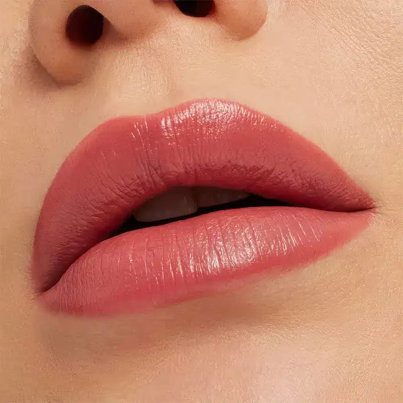 A imagem mostra a boca de uma mulher usando o batom.
