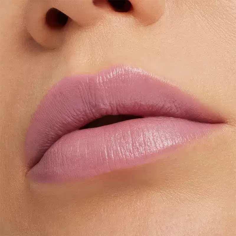 A imagem mostra a boca de uma mulher usando o batom.