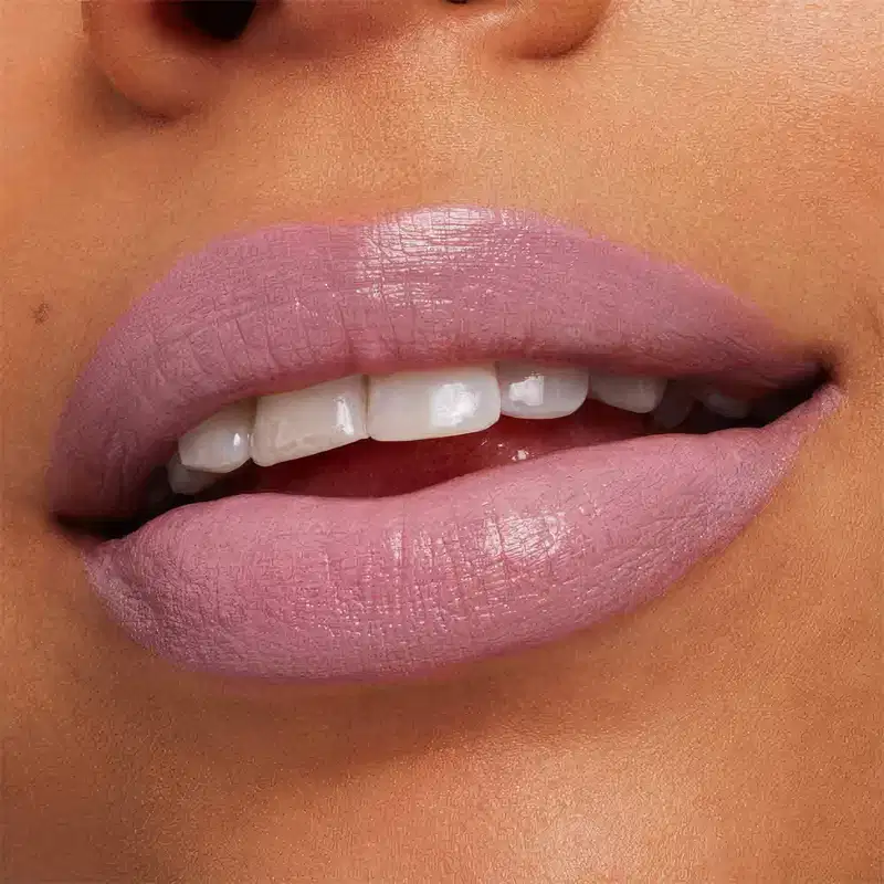 A imagem mostra a boca de uma mulher usando o batom.
