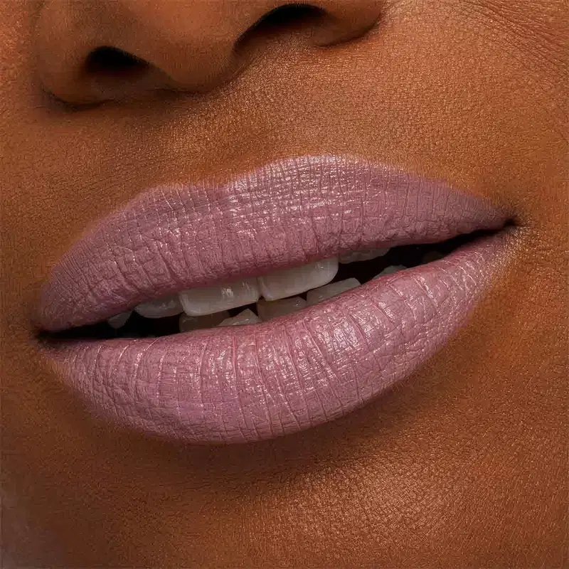 A imagem mostra a boca de uma mulher usando o batom.
