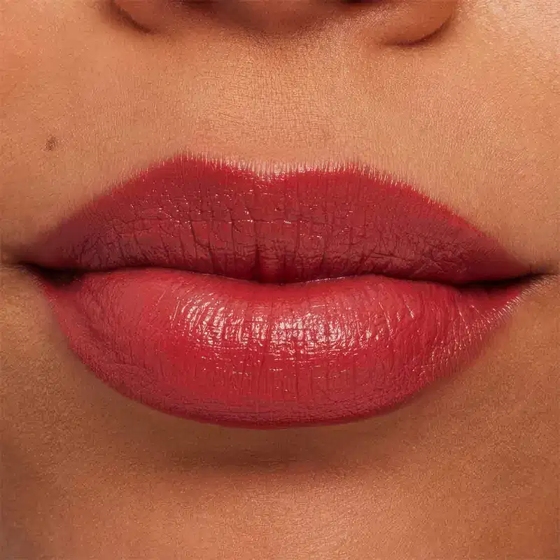 A imagem mostra a boca de uma mulher usando o batom.