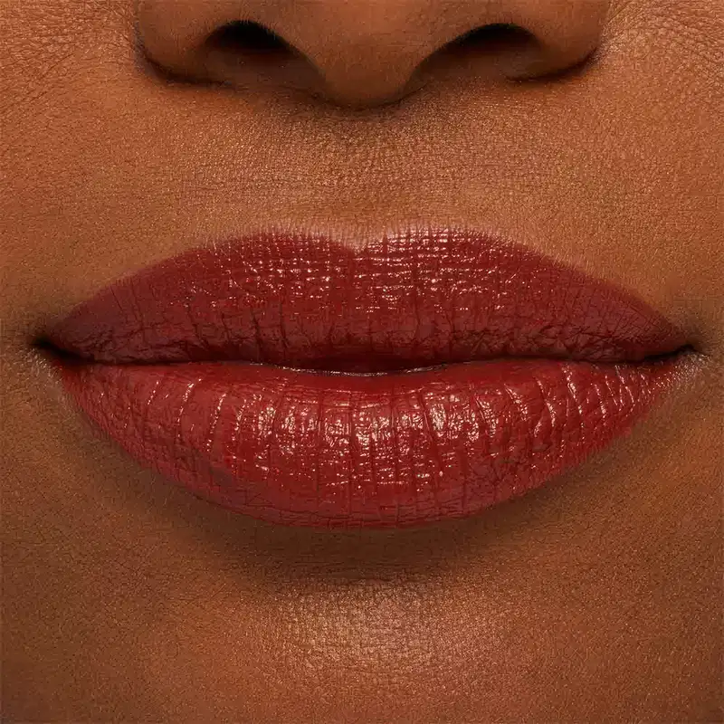 A imagem mostra a boca de uma mulher usando o batom.