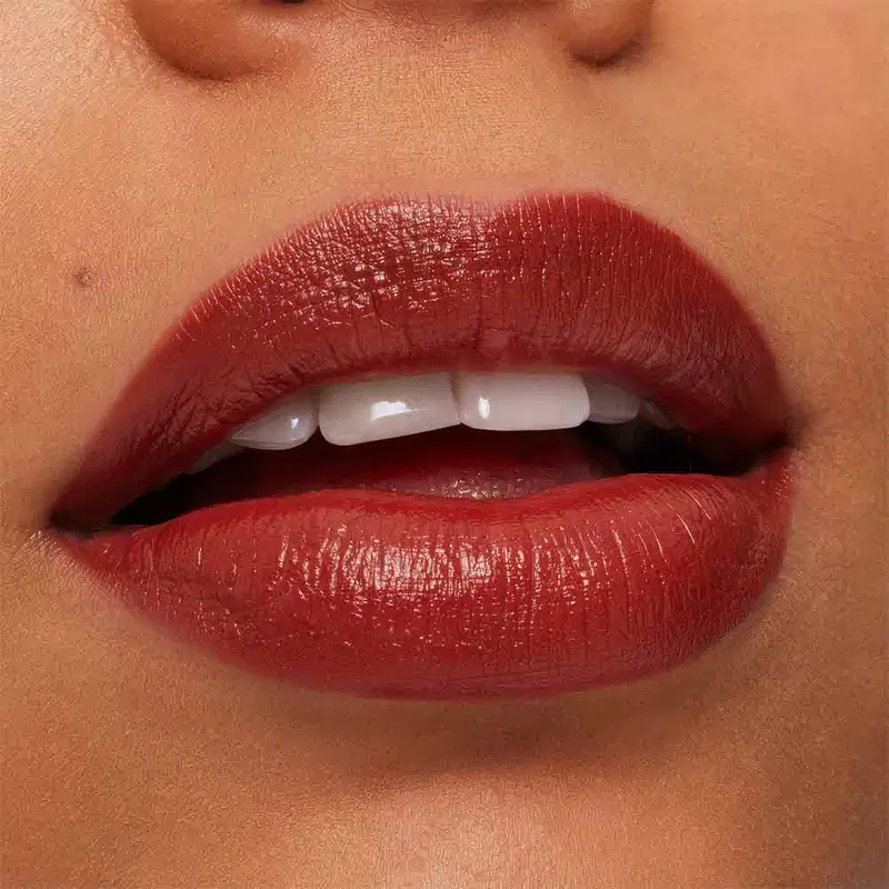 A imagem mostra a boca de uma mulher usando o batom.