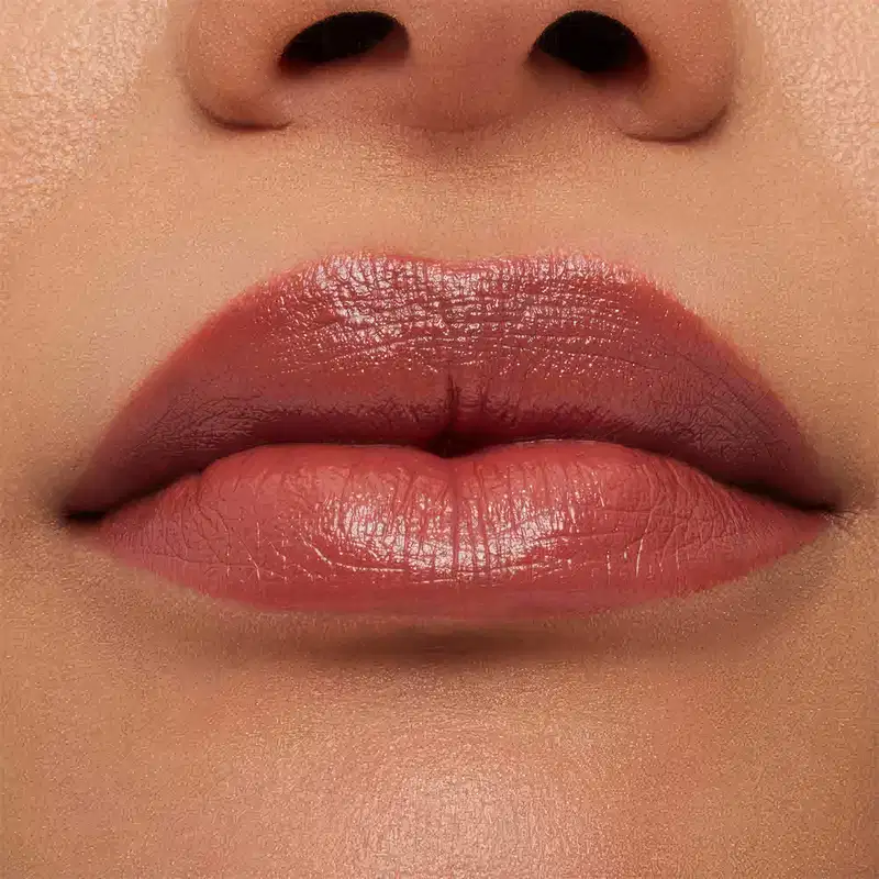 A imagem mostra a boca de uma mulher usando o batom.