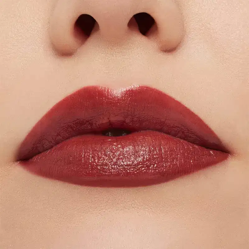 A imagem mostra a boca de uma mulher usando o batom.
