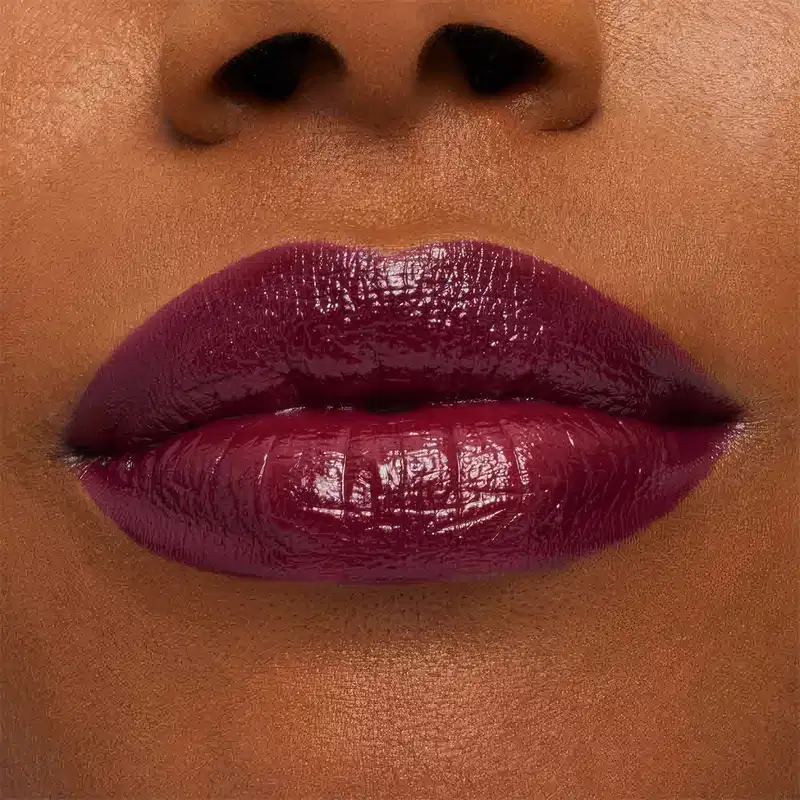 A imagem mostra a boca de uma mulher usando o batom.
