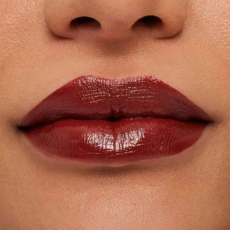 A imagem mostra a boca de uma mulher usando o batom.