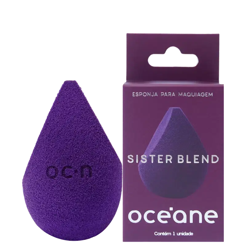 Esponja para maquiagem triangular de cor roxa. Ao lado, embalagem retangular roxa com abertura para pendurar, contendo o logotipo "Océane" e a inscrição "Sister Blend" em letras brancas.