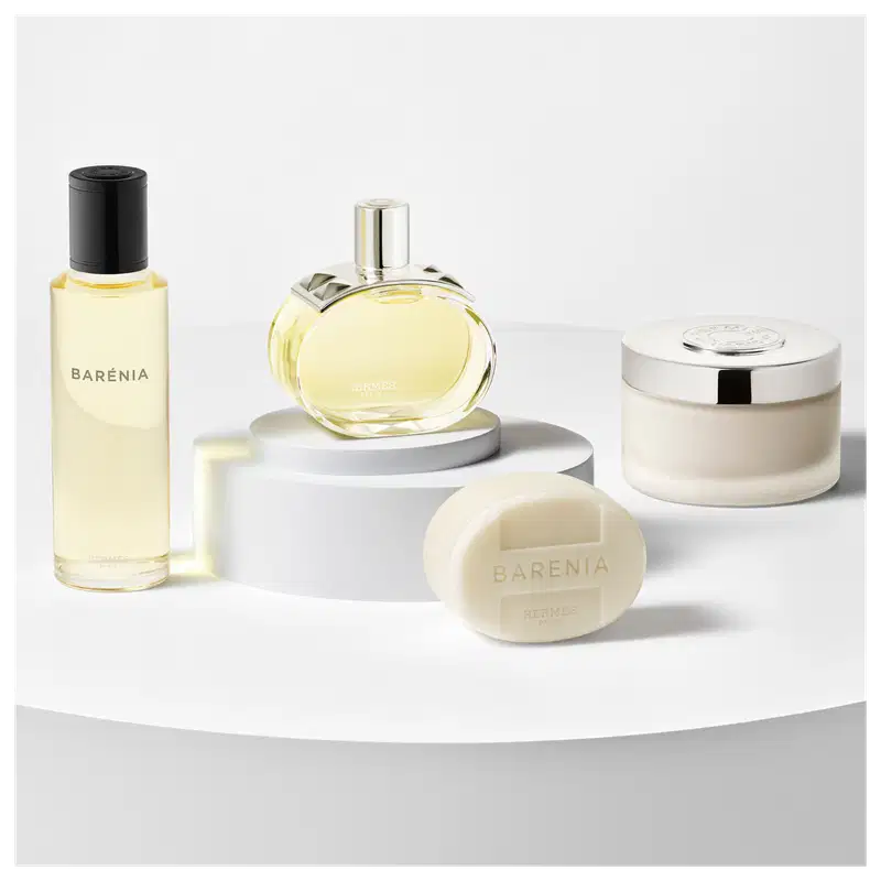 A imagem mostra uma seleção de produtos de Barénia, um refil, o frasco do perfume, um sabonete e um pote redondo com a tampa prateada.