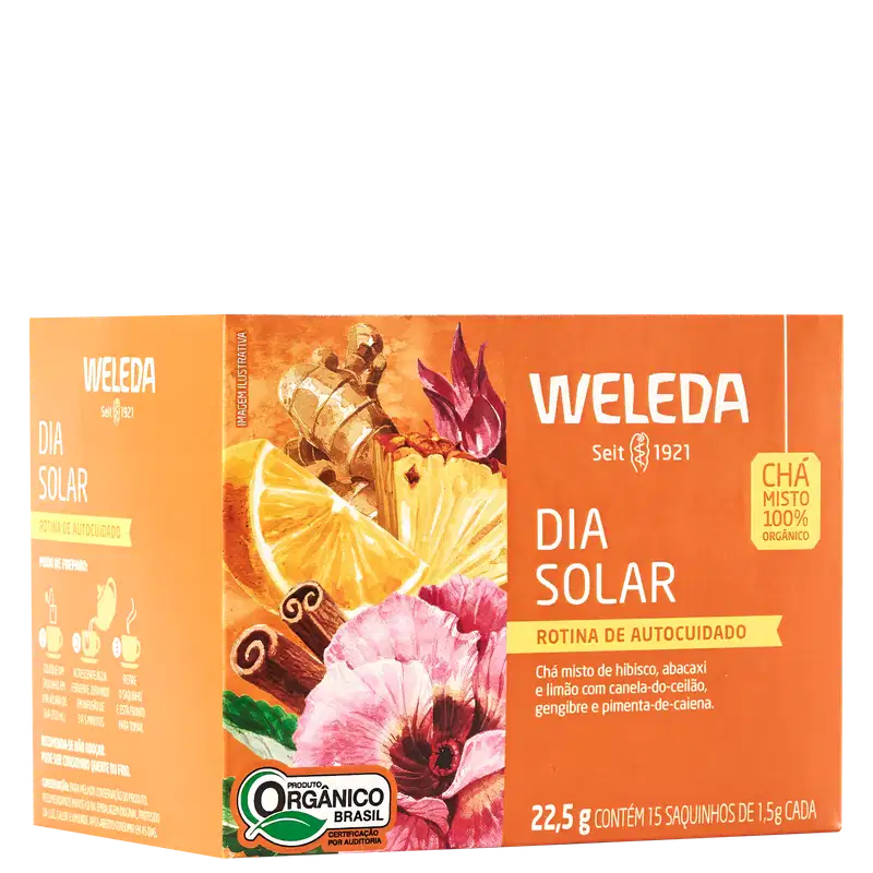 A imagem mostra a embalagem do chá em uma caixa retangular laranja com imagens de frutas cítricas, especiarias e flores. Texto em português descrevendo os ingredientes.
