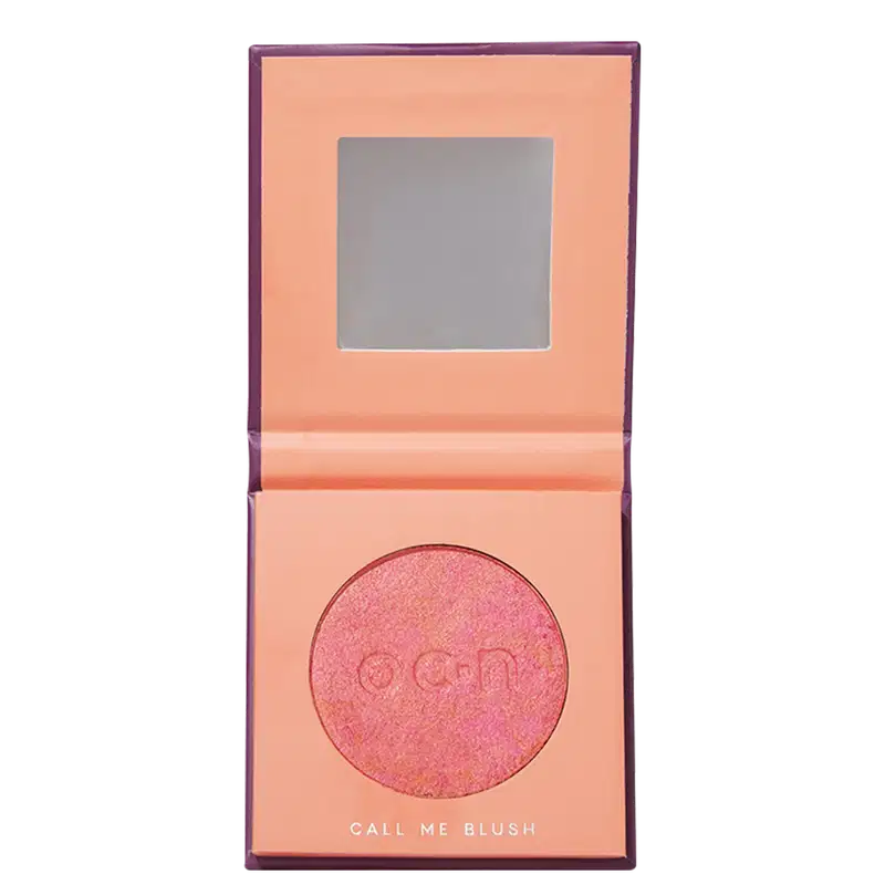 A embalagem está aberta mostrando um espelho na parte superior e o blush compacto em tom de laranja.
