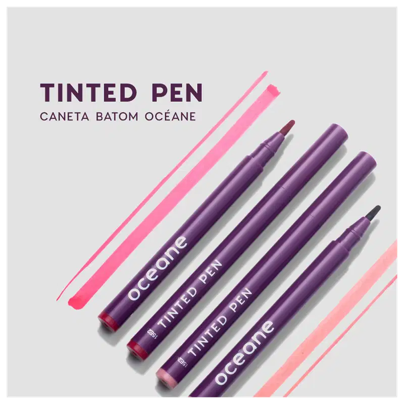 Tinted Pen, caneta batom da marca Océane. Conjunto de quatro canetas com embalagens roxas.. As canetas apresentam o nome da marca "Océane" e "Tinted Pen" impressos em letras brancas. O fundo da imagem tem listras diagonais em tons de rosa e vermelho claro