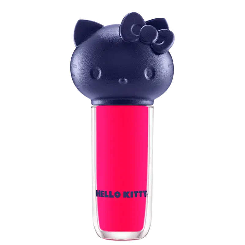 Produto de maquiagem em formato cilíndrico com a cabeça da personagem Hello Kitty como tampa. A parte superior é azul escuro com detalhes que representam os olhos, orelhas e laço da Hello Kitty. É possível ver a cor do produto pelo corpo transparente.