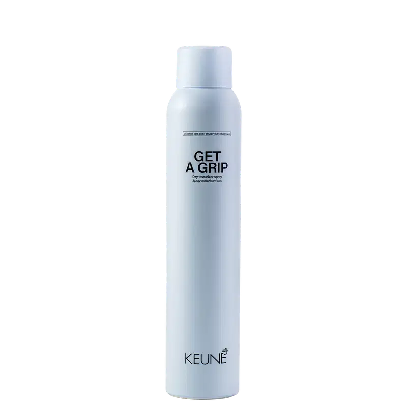 A imagem mostra o produto Keune Get a Grip. Embalagem cilíndrica azul claro. Nome do produto "Get a Grip Dry texturizer spray" e logotipo da Keune em letras pretas.