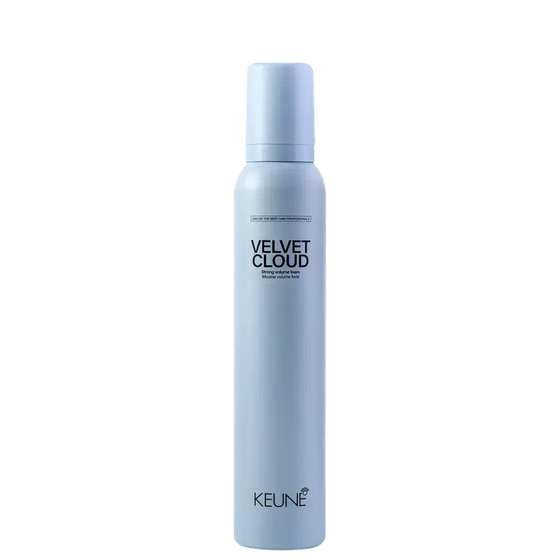 A imagem mostra a Mousse Volumadora Velvet Cloud da marca Keune. É apresentado em um frasco cilíndrico branco azulado opaco. Exibe o nome do produto "Velvet Cloud" em letras pretas maiúsculas, seguido da descrição "Mousse volume foam" em letras menores.