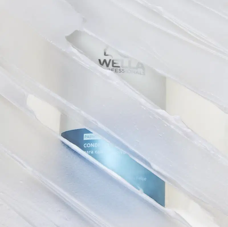 Embalagem de produto da marca Wella Professionals, com frasco de condicionador em fundo branco translúcido, sugerindo um ambiente de cuidados capilares profissionais.