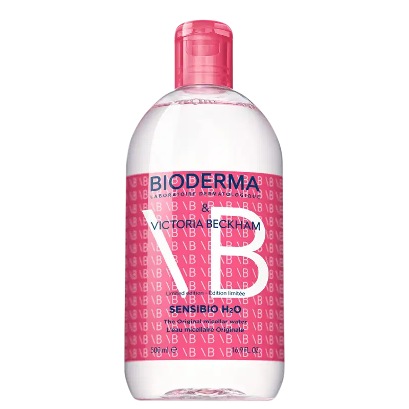 Frasco de 500 ml de água micelar Sensibio H2O da Bioderma, em edição limitada com design exclusivo da Victoria Beckham, com predominância de cores rosa e branca.