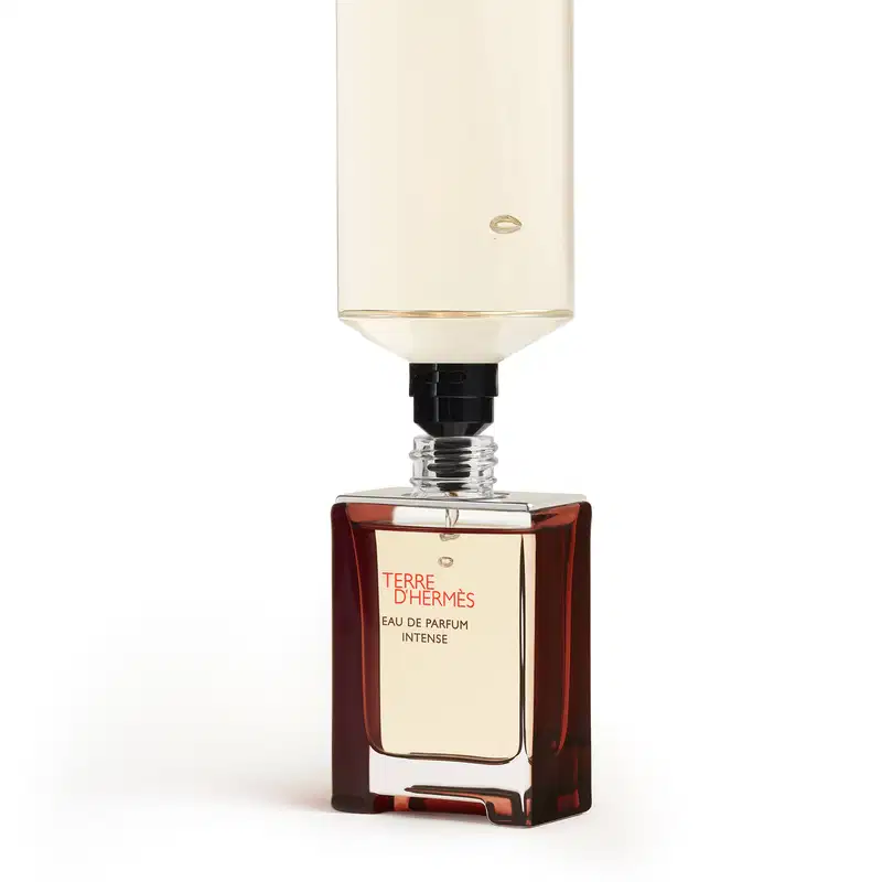 Frasco de perfume Terre d'Hermès Eau de Parfum Intense, com embalagem retangular em vidro âmbar e tampa preta. Rótulo com o nome da fragrância em letras vermelhas.