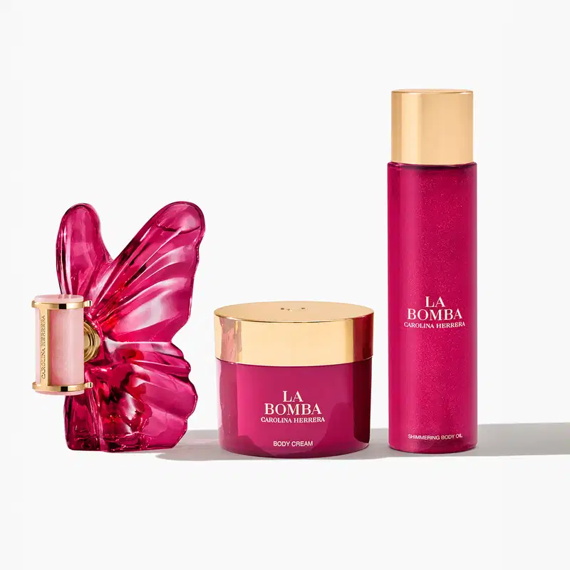 Produtos de beleza da marca Carolina Herrera, incluindo um frasco de perfume com tampa dourada, um pote de creme corporal e um frasco de óleo corporal brilhante, todos em tons de rosa vibrante.