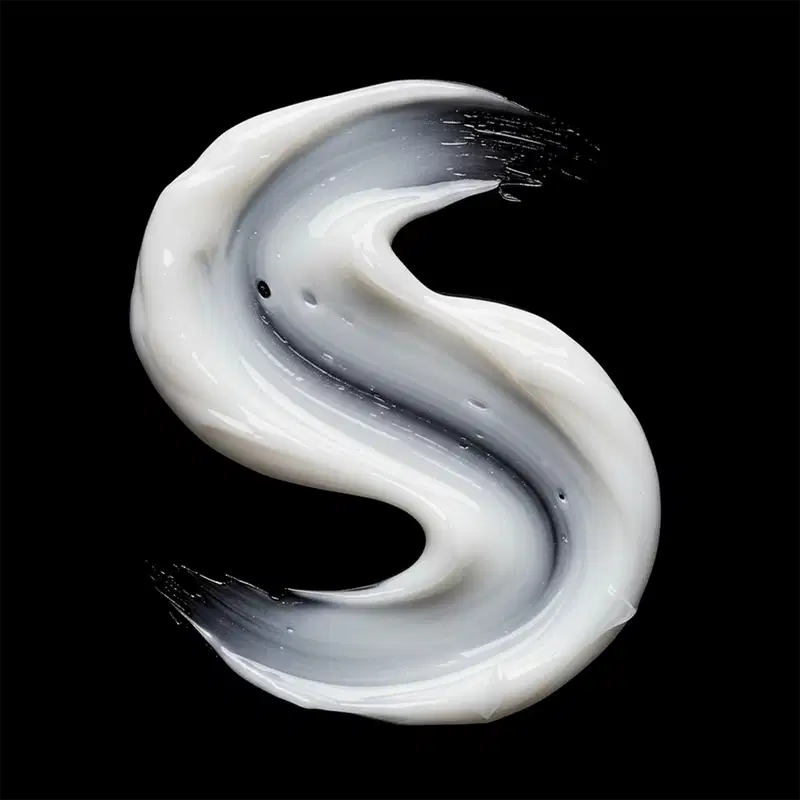 A textura do produto apresenta uma aparência cremosa e sedosa, com tonalidades de branco e cinza que se fundem em um movimento fluido e sinuoso, criando uma impressão de suavidade e leveza.