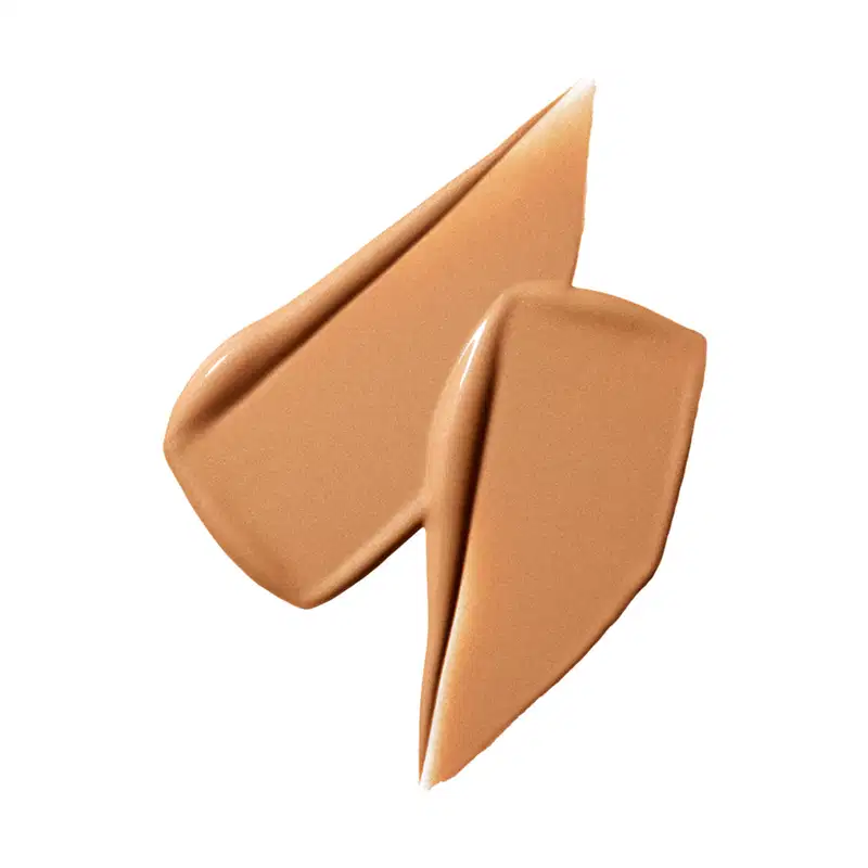 A textura deste produto de beleza é cremosa e sedosa, com uma tonalidade dourada e brilhante. Sua aparência sugere uma consistência suave e aveludada, que provavelmente proporciona uma aplicação uniforme e fácil absorção na pele.