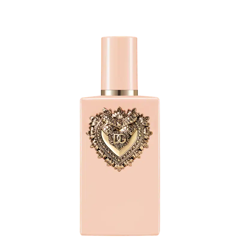 Frasco de item de perfumaria com tampa dourada em formato de coração ornamentado. Embalagem rosa clara com detalhes dourados. 