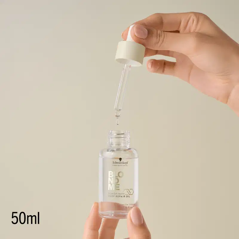 Mão segurando um frasco de óleo reparador da linha Bondfinity da Schwarzkopf Professional, em um ambiente claro e minimalista, com foco no produto e sua embalagem.