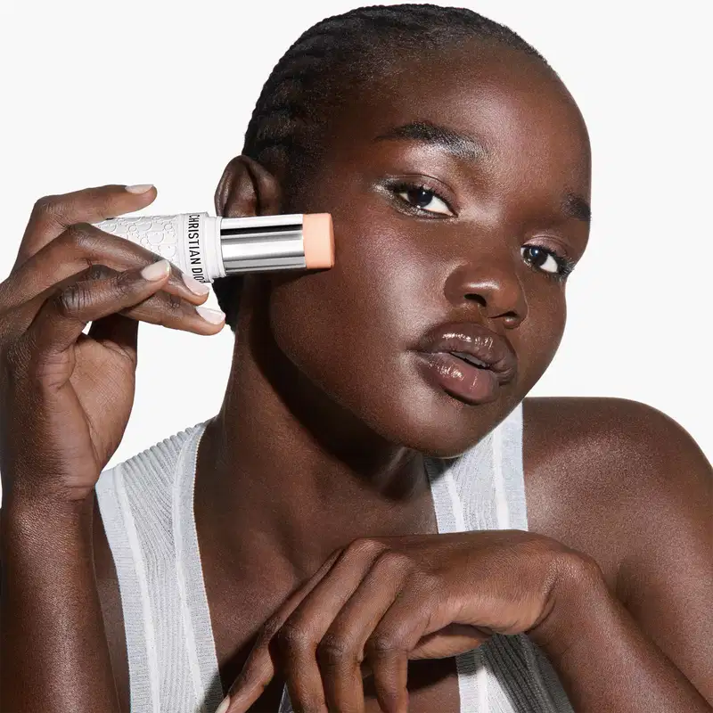 Modelo aplicando o Protetor Solar Facial em Bastão 