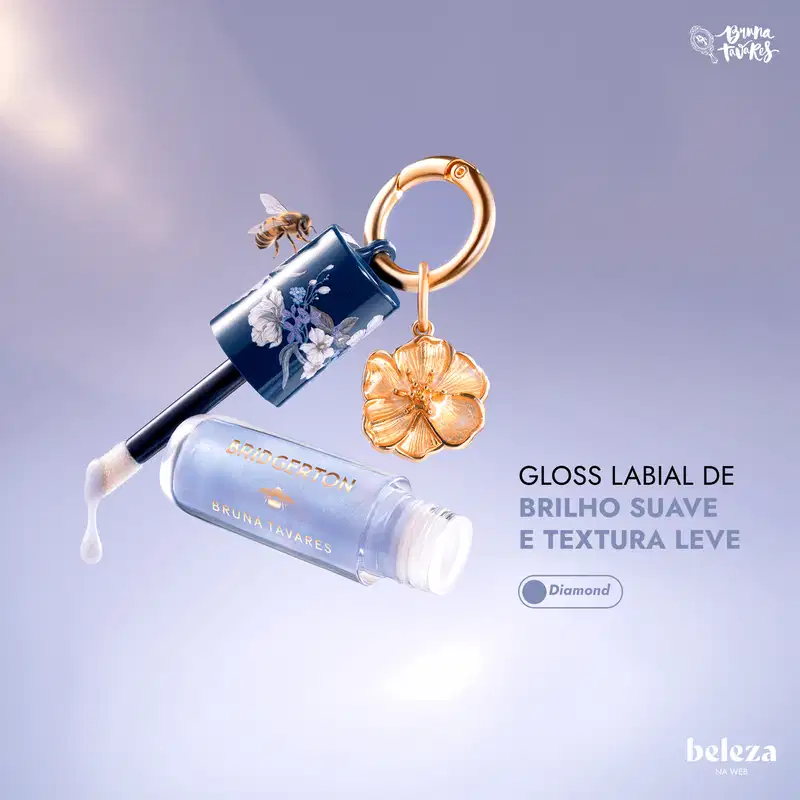Embalagem de gloss labial da marca Bruna Tavares com textura suave e brilho, na cor Diamond, acompanhada de pingente dourado em formato de flor.