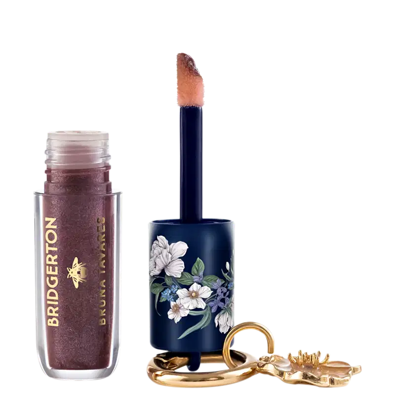 Gloss labial da marca Bruna Tavares, em tom marrom rosado, com detalhes florais em azul e branco na tampa.