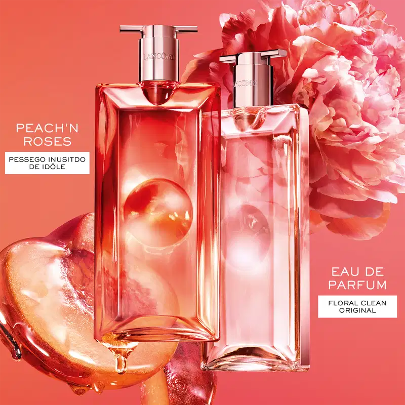 Dois frascos de item de perfumaria da marca Lancôme em embalagens de vidro com detalhes em rosa, contendo líquido avermelhado, rodeados por flores de peônia rosa.