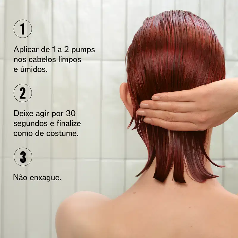 A imagem mostra uma pessoa aplicando o produto em seus cabelos vermelhos. Ao lado texto com instruções de uso: Aplicar de 1 a 2 pumps nos cabelos limpos e úmidos. Deixar agir por 30 segundos e finalizar como de costume. Não enxague.