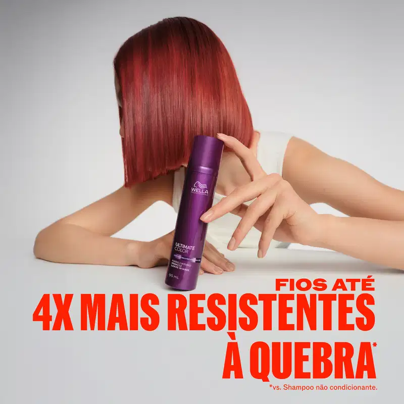 A imagem mostra uma mulher com cabelos vermelhos segurando embalagem roxa da marca Wella. Fundo branco com texto promocional em vermelho destacando o texto: Fios até 4x mais resistentes à quebra.