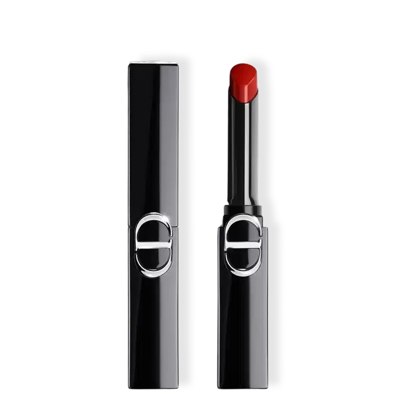 Batom Dior com embalagem preta e aplicador cilíndrico, exibindo cor vermelha intensa na ponta, com logo circular prateado na frente do tubo.