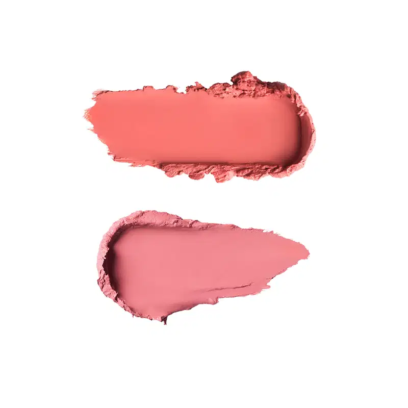 Duas amostras de texturas de maquiagem: amostra superior em tom coral avermelhado com acabamento cremoso e brilhante; amostra inferior em tom rosa claro com textura matte e acabamento pulverulento.