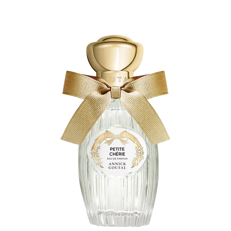 Eau de Parfum Petite Chérie da Annick Goutal em frasco de cristal com tampa dourada em formato de cúpula. Embalagem decorada com laço de fita bege e rótulo circular com detalhes florais dourados.