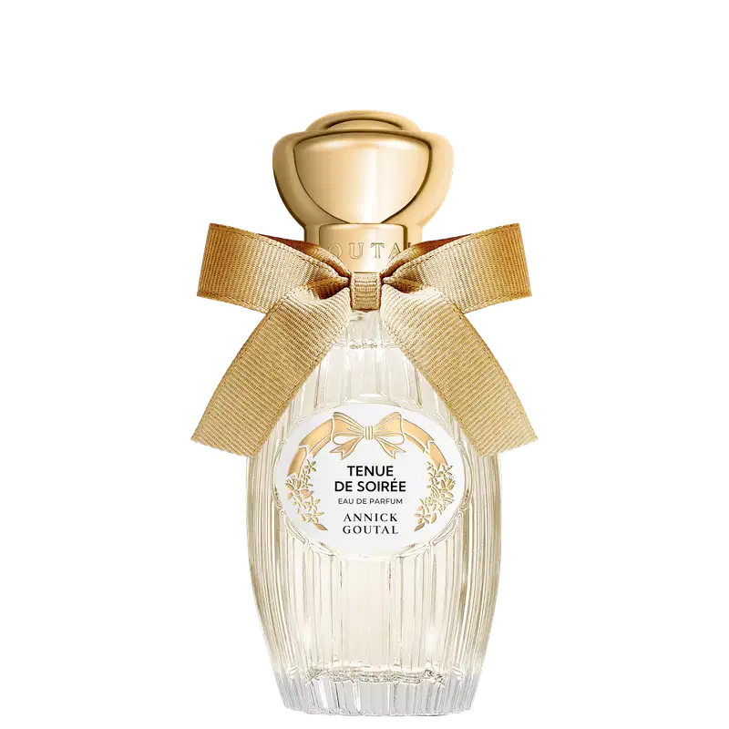 Eau de Parfum Tenue de Soirée da Annick Goutal em frasco de cristal transparente com tampa dourada esférica. Apresenta laço de fita bege e rótulo circular branco com detalhes florais dourados.